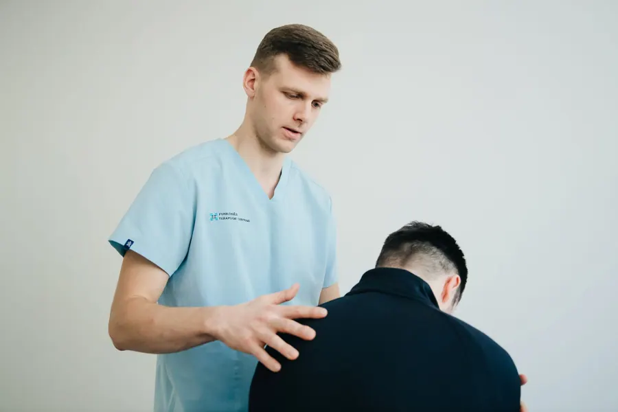 Daan onderzoekt de schouder van een patiënt