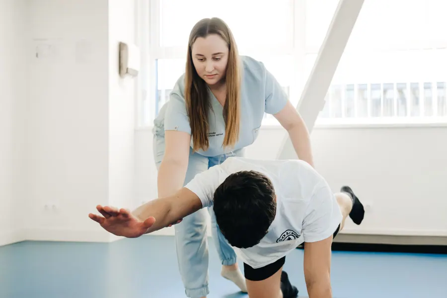 Sanne begeleidt een oefening op handen en knieën