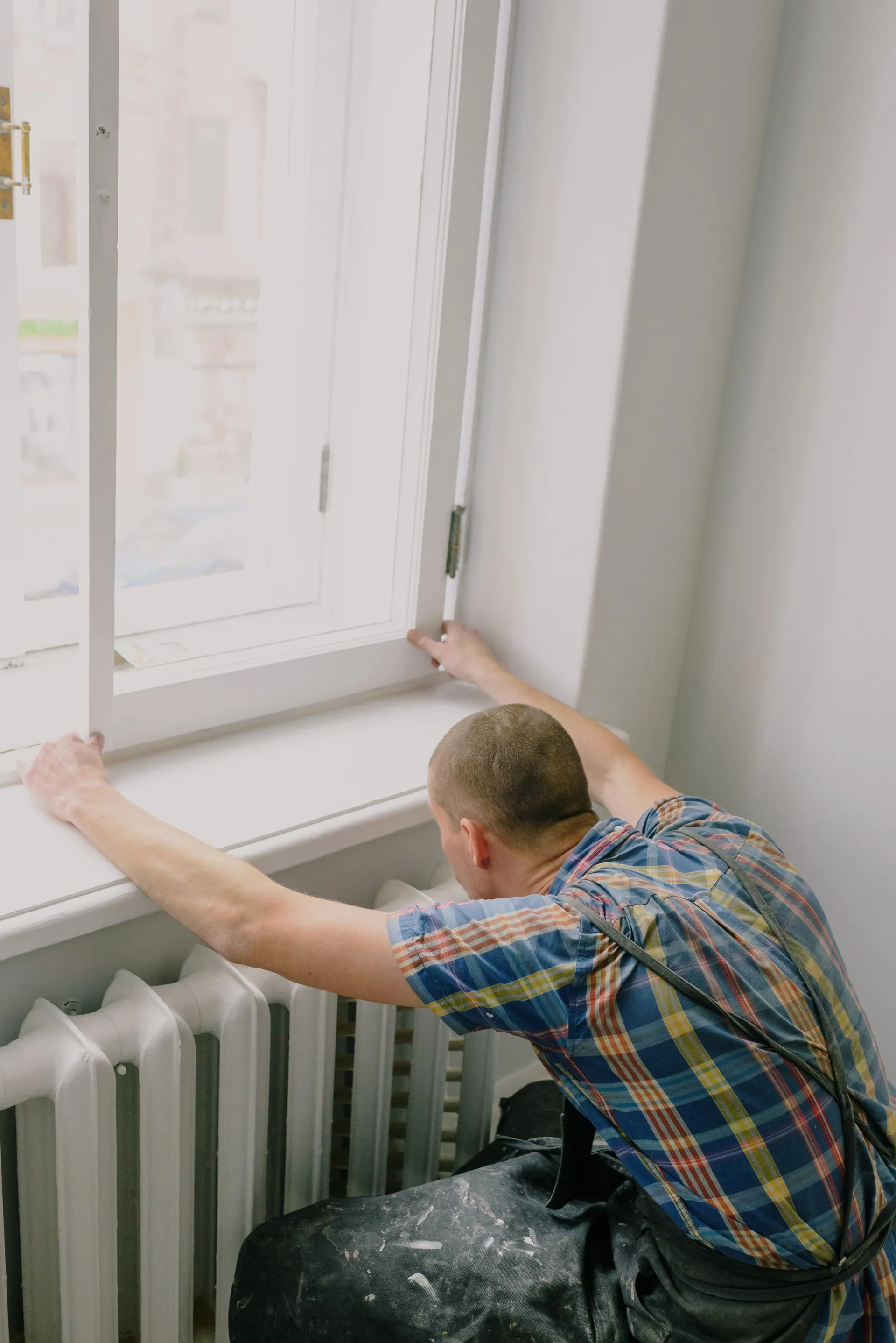 Een vensterbank wordt afgewerkt onder een nieuw kozijn