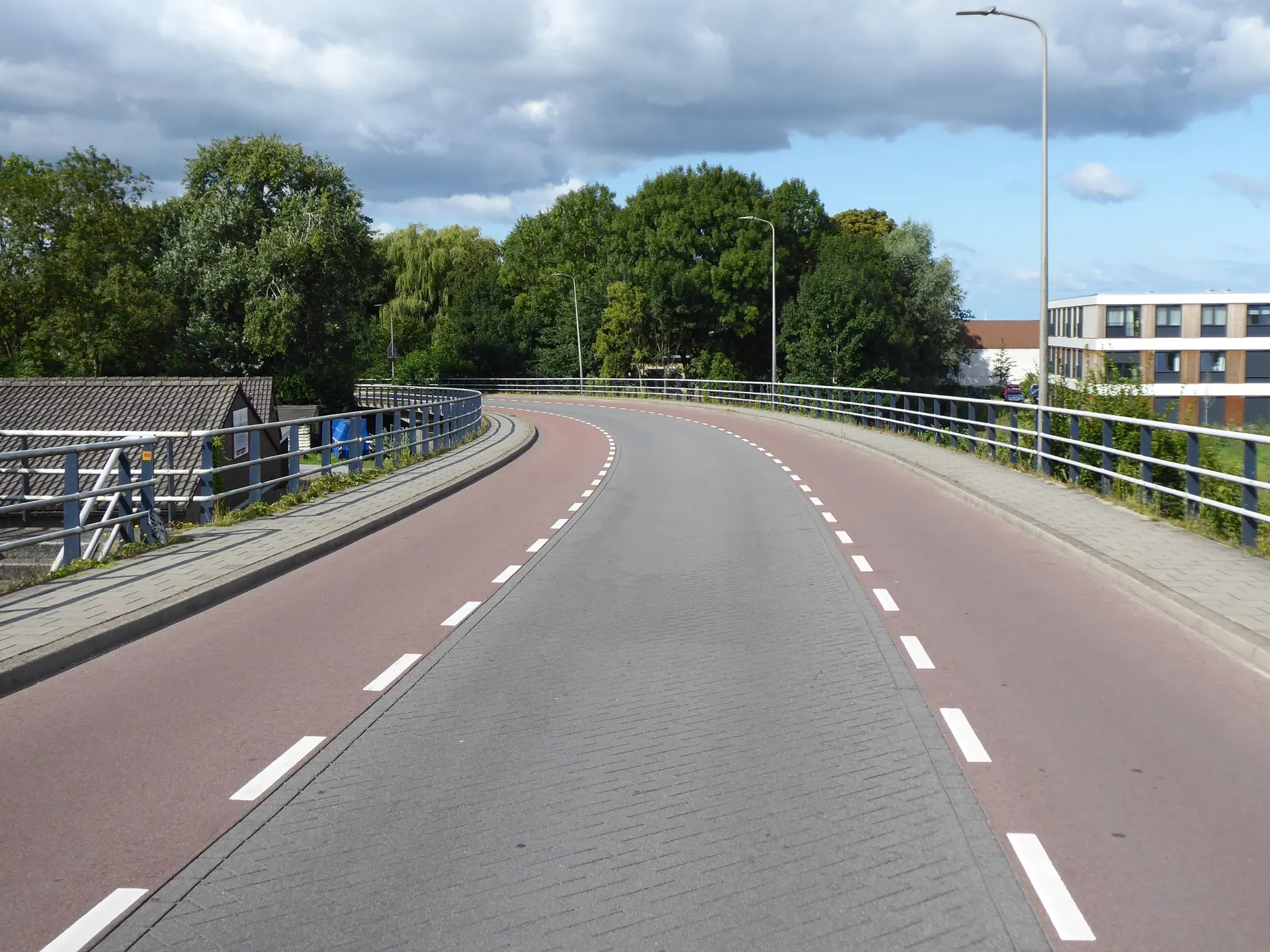 Een lege weg met een fietspad ernaast op een bewolkte dag