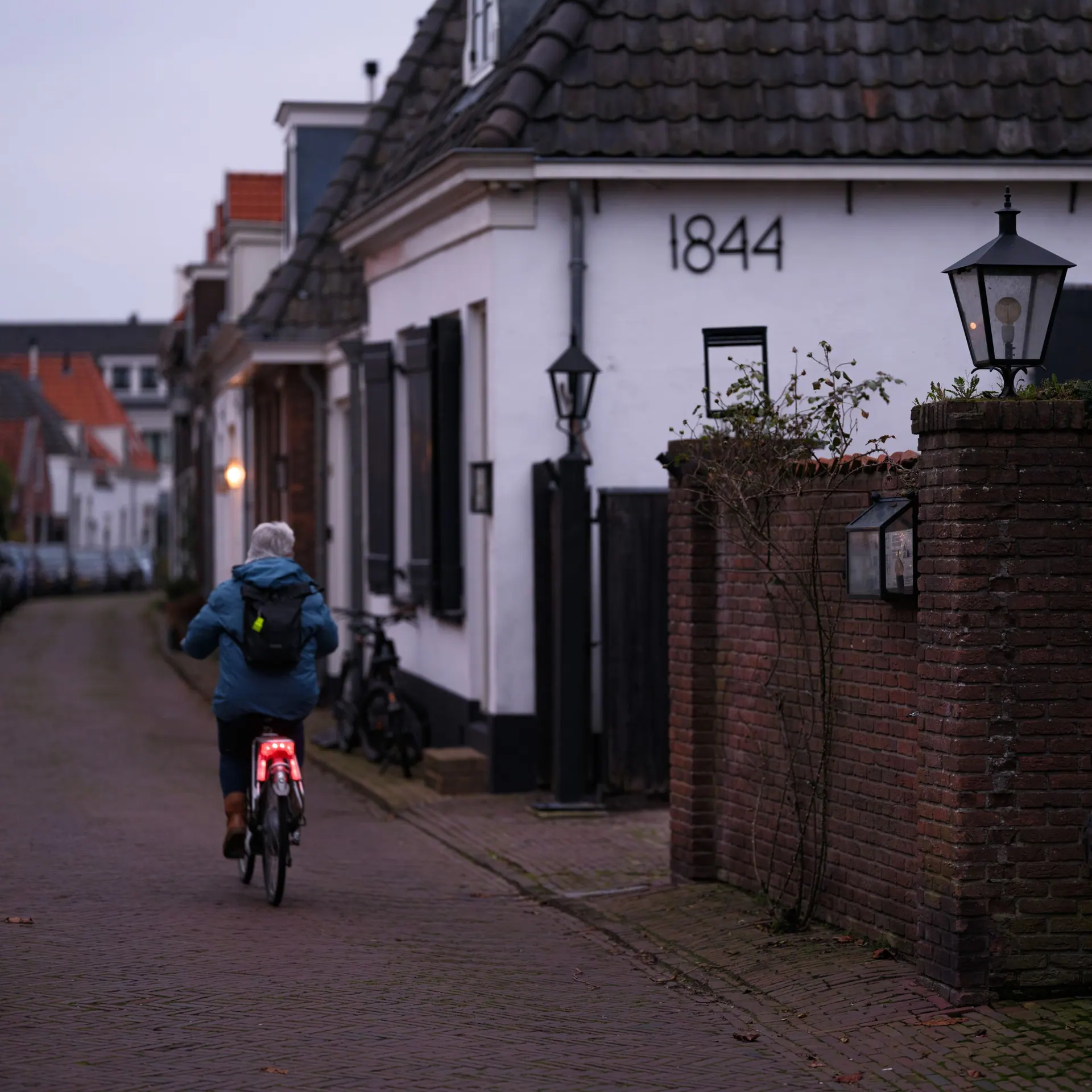 Een fietser in een straat van Naarden-Vesting bij avond